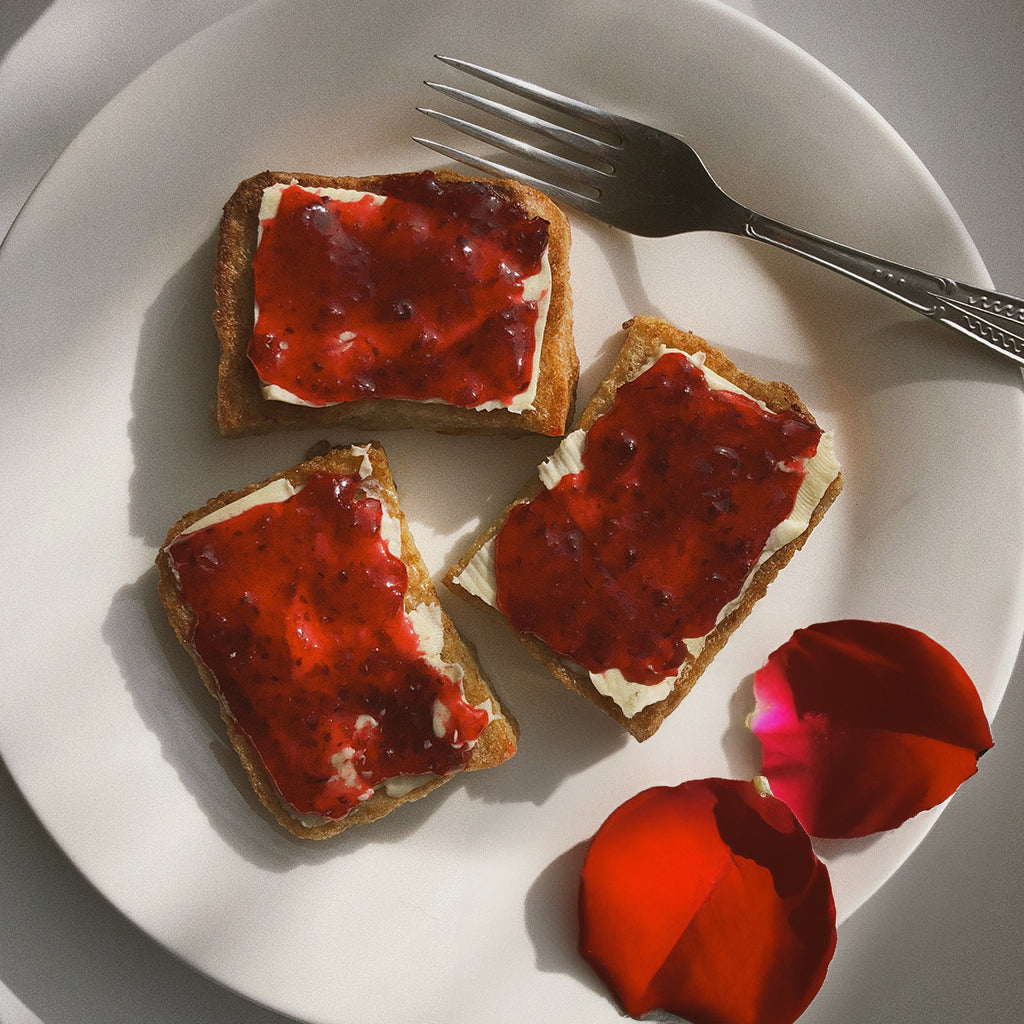 toast and butter with strawberry jam on top